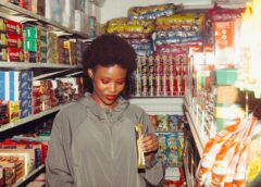 positive ethnic woman choosing food in grocery store