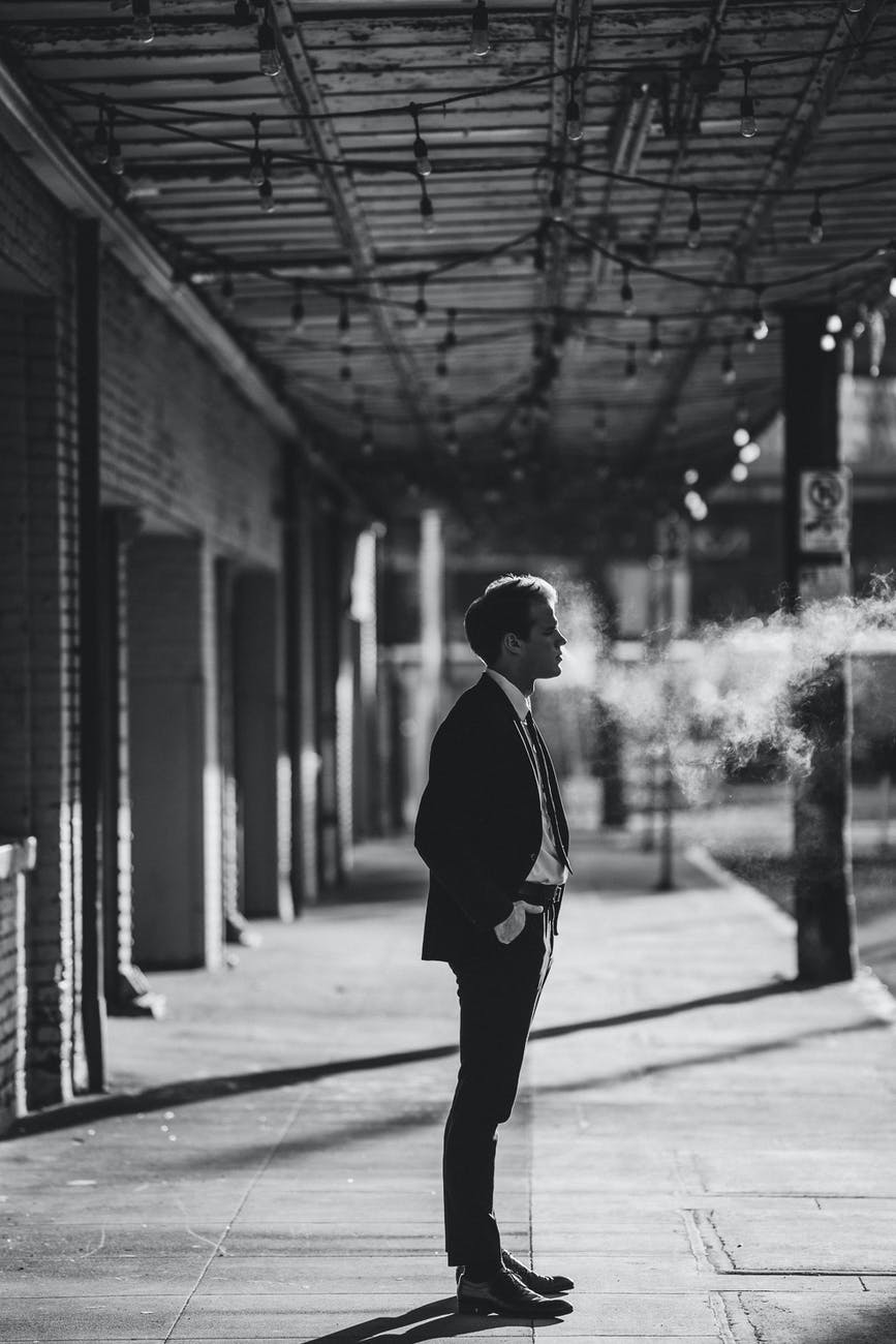 businessman against smokey on roofed walkway in town