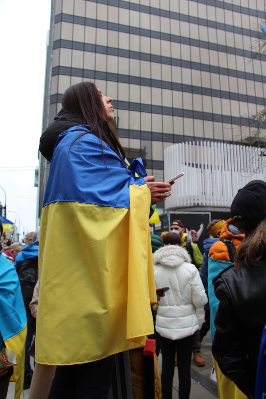 a woman wrapped in the national flag of ukraine during a peaceful protest in canada