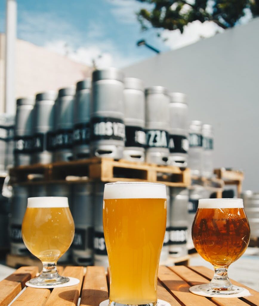 three assorted drinking glasses with beer