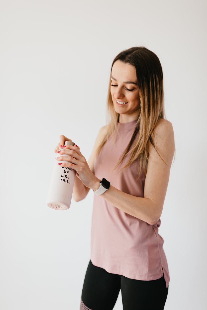 cheerful sportswoman with bottle of water