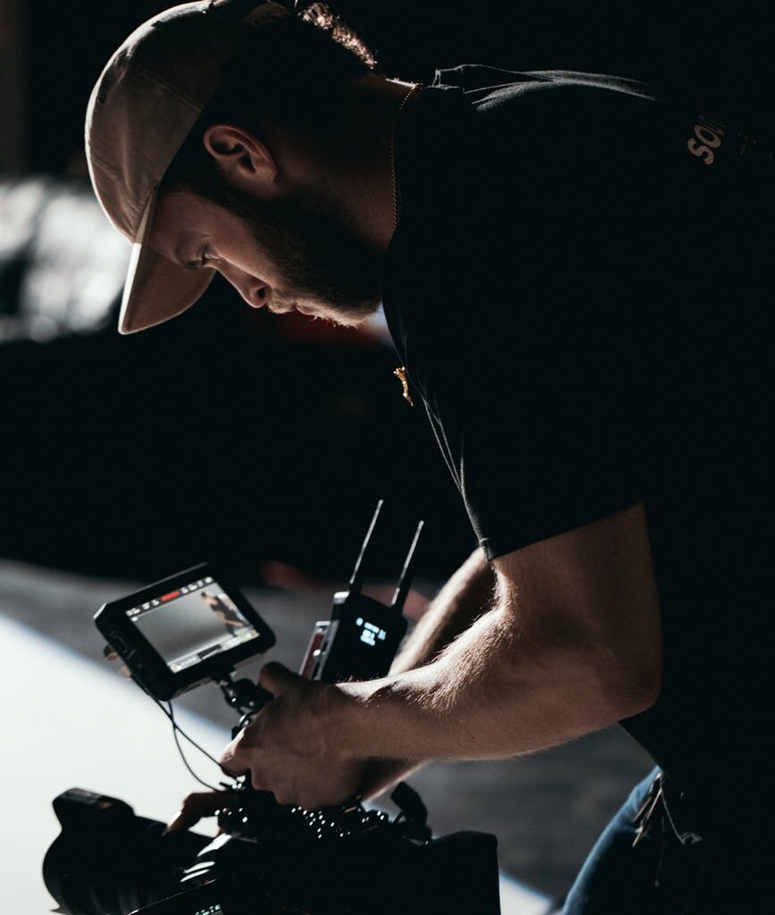 man in black t shirt holding black digital camera