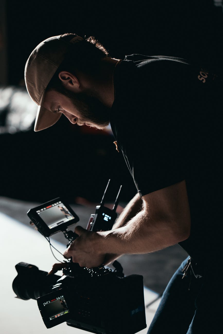 man in black t shirt holding black digital camera