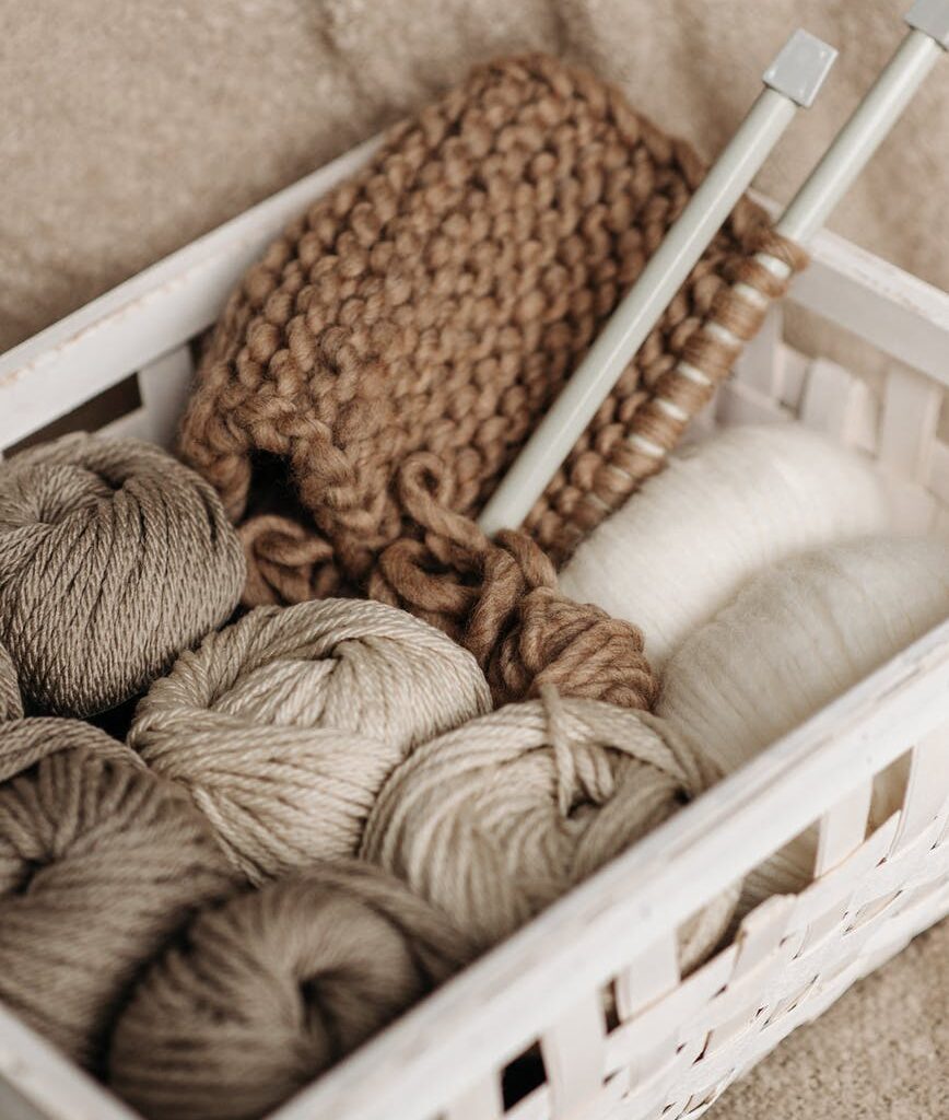 white and brown yarns in basket