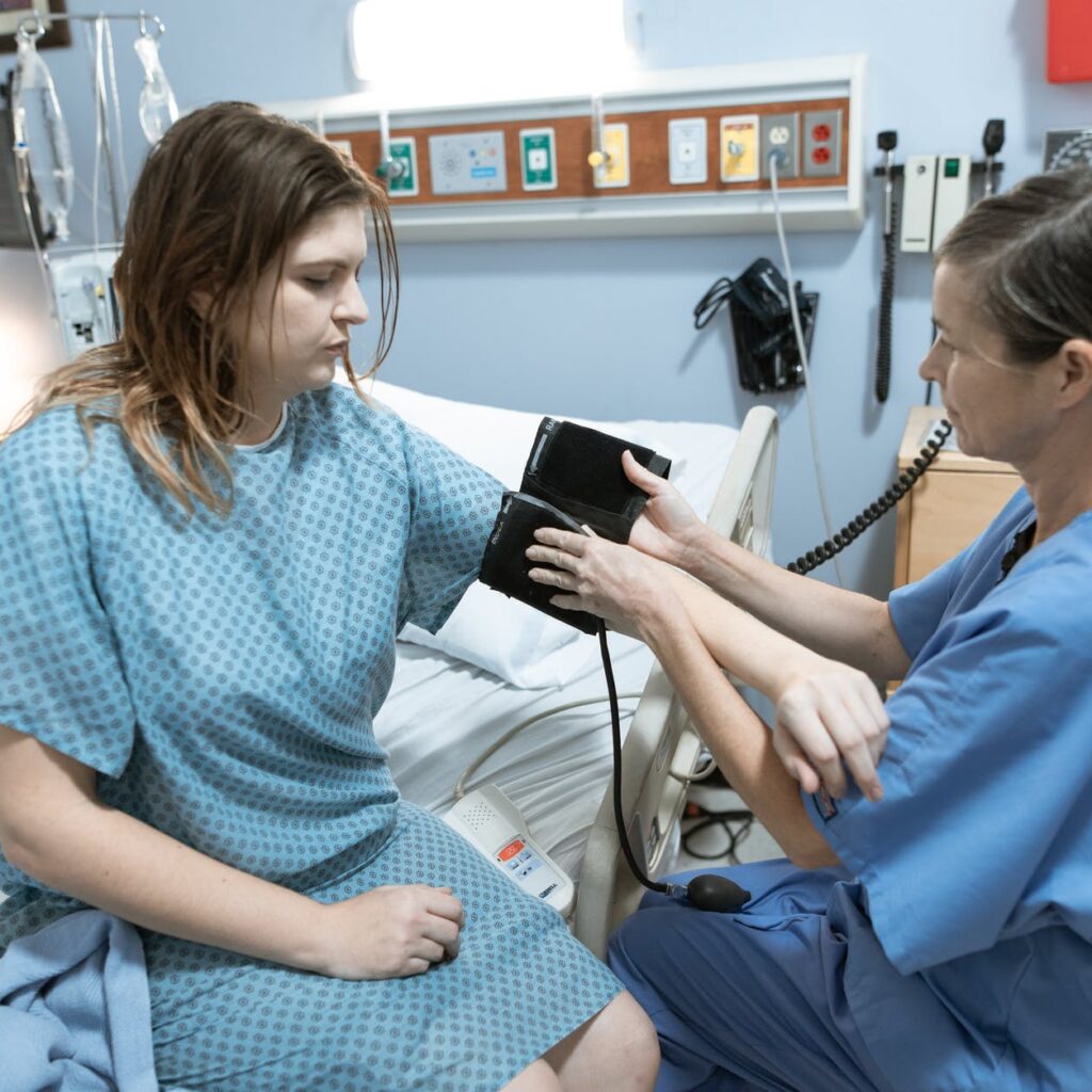 nurse taking the blood pressure of a patient