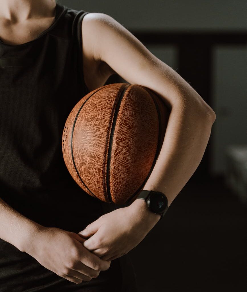 woman in black tank top holding a ball