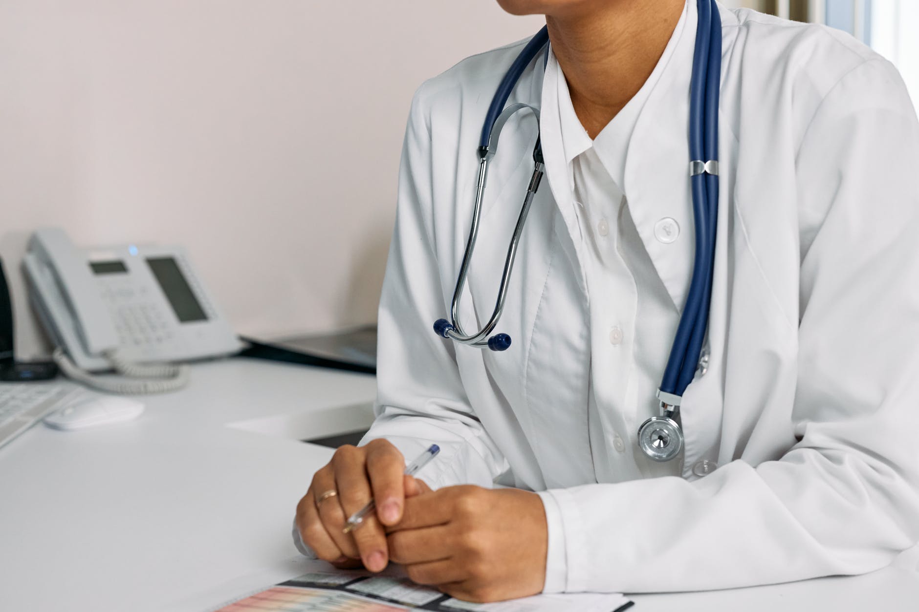 person in white scrub suit using white laptop computer