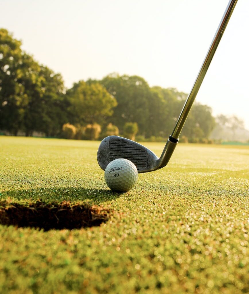 golf club hitting ball on field