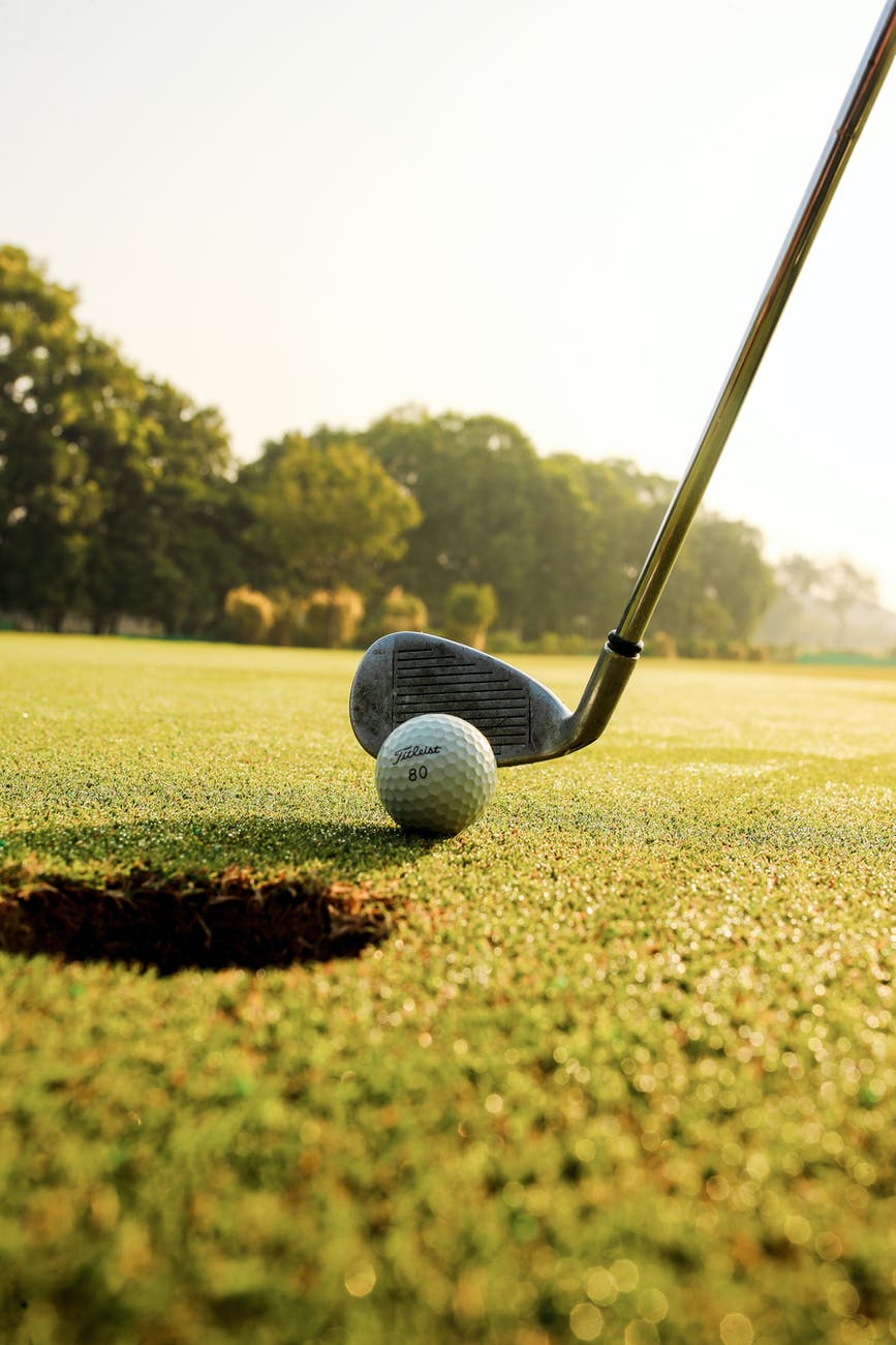 golf club hitting ball on field