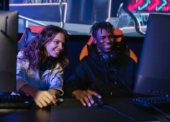 man and woman smiling while playing videogame