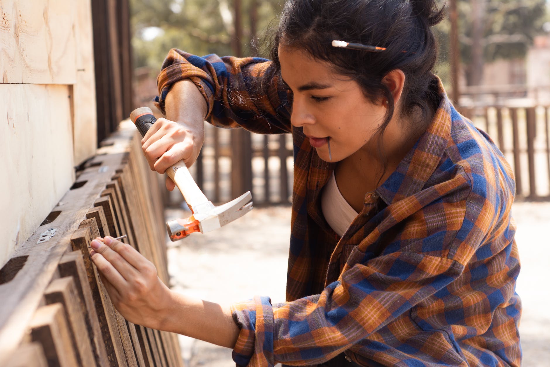 woman in brown scarf and blue and brown plaid dress shirt holding white plastic cup