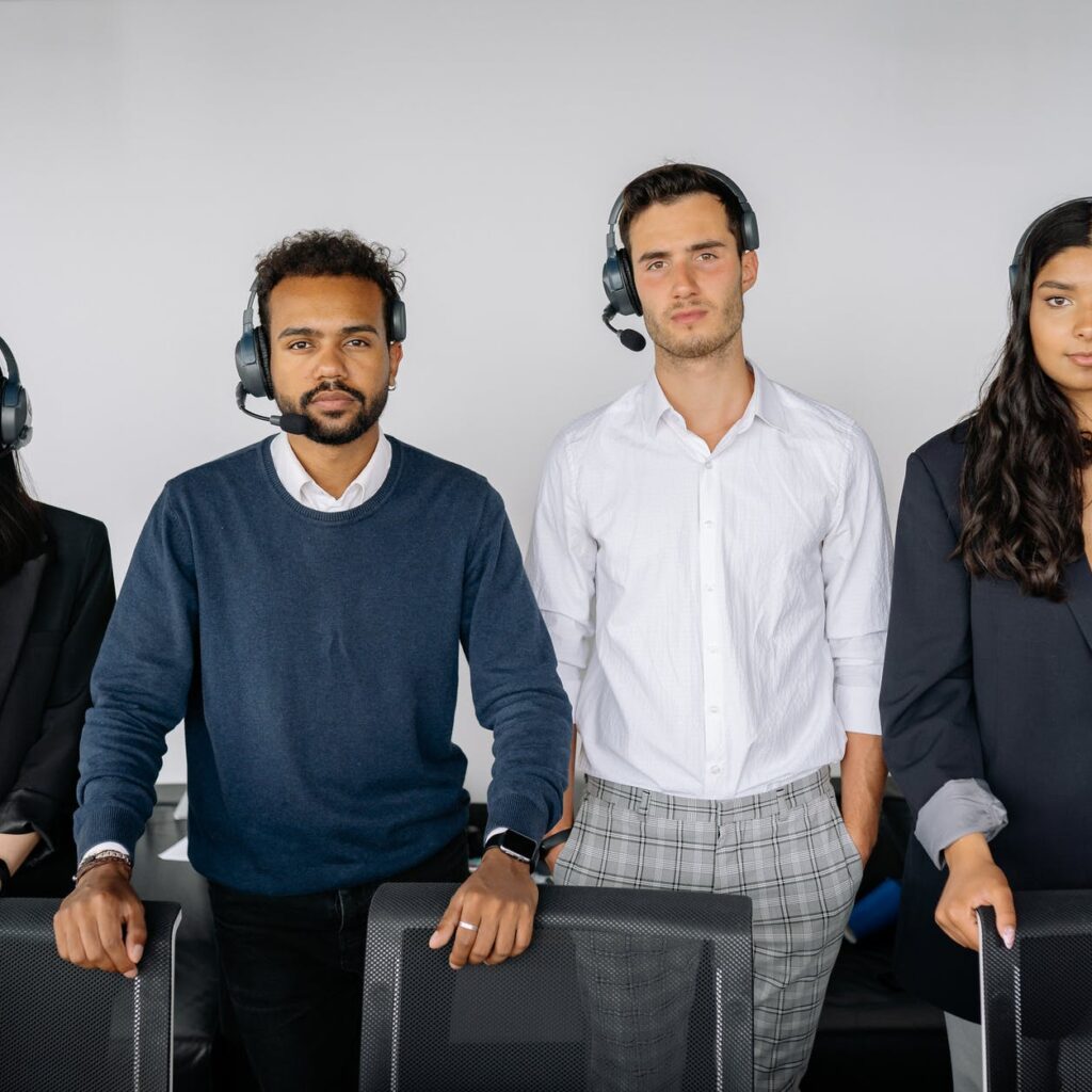 people wearing headsets standing behind chairs