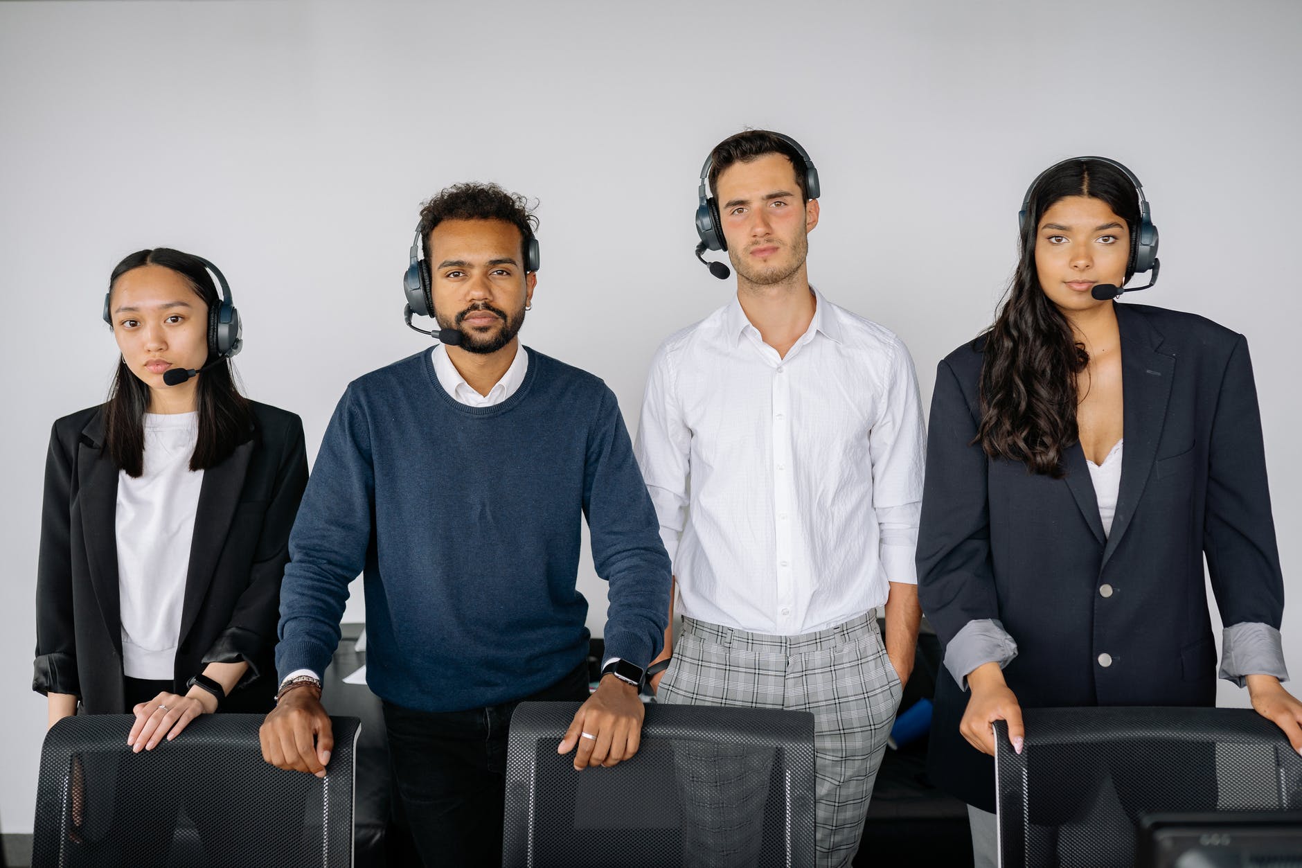 people wearing headsets standing behind chairs