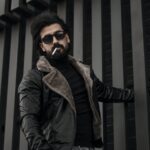 man in brown jacket wearing black sunglasses