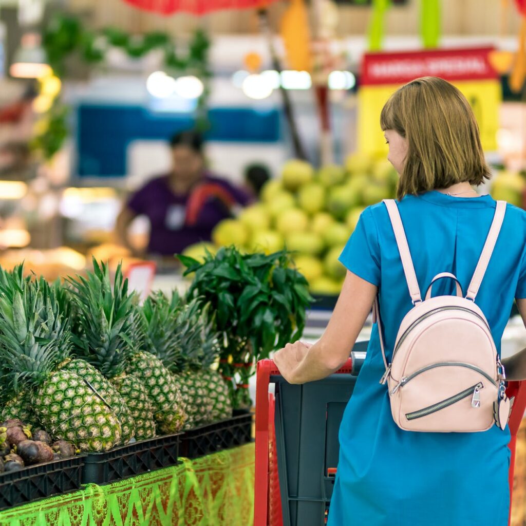 woman standing beside pineapple fruits