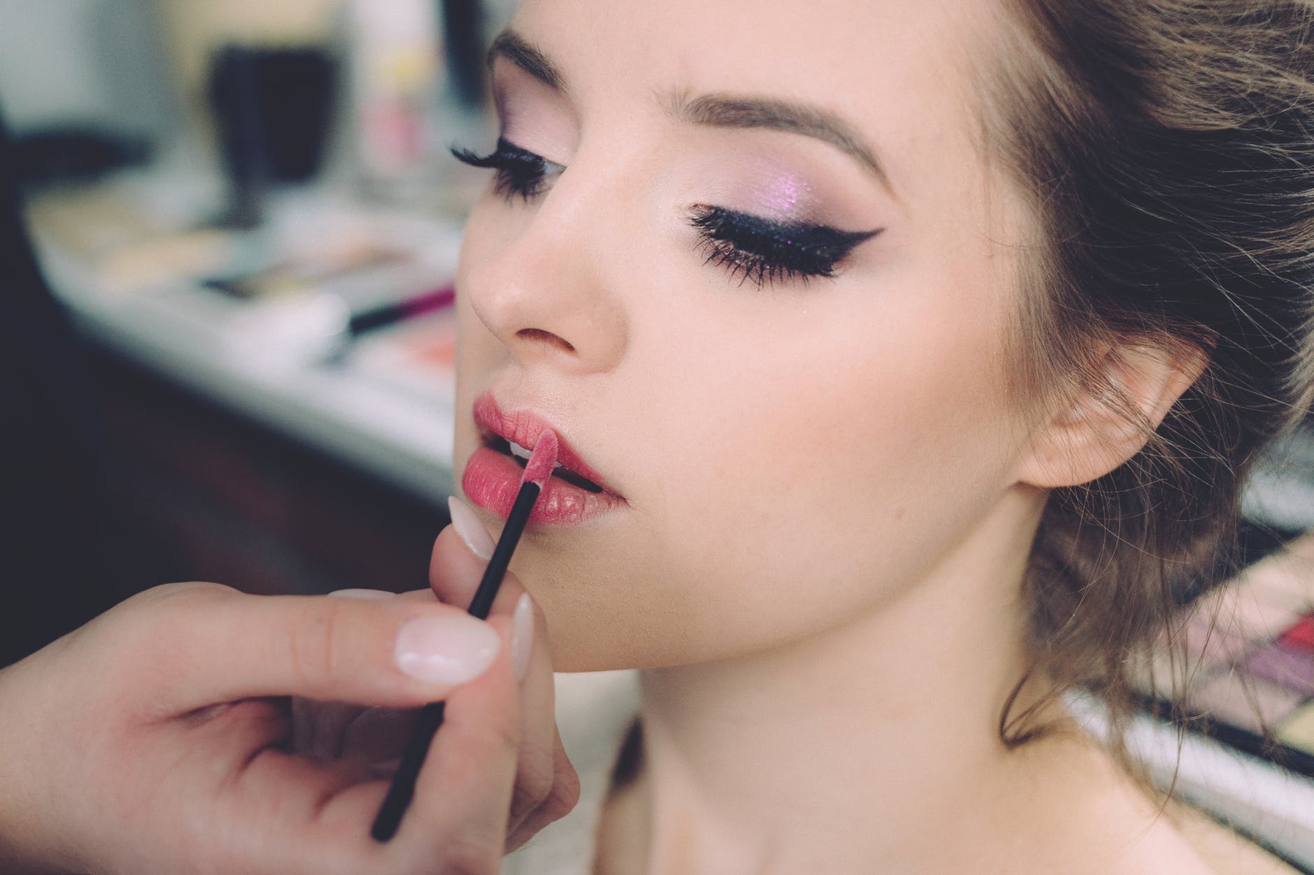 woman putting on lipstick