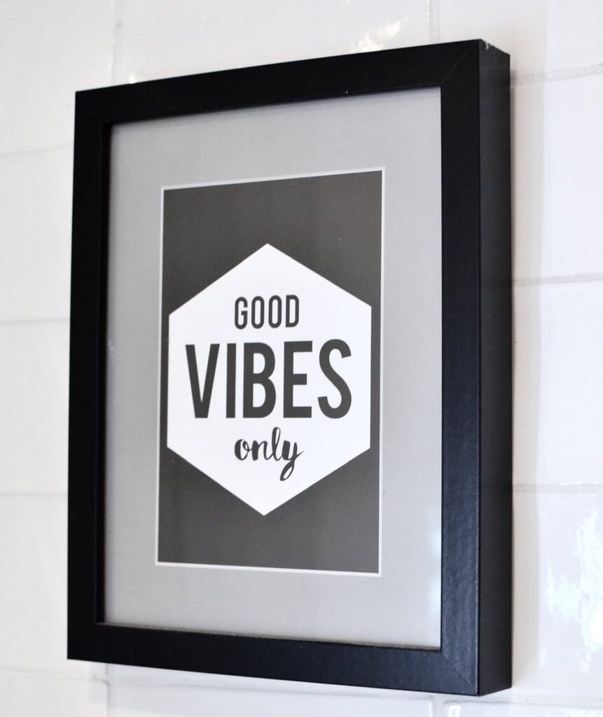 framed picture with inspirational text hanging on wall