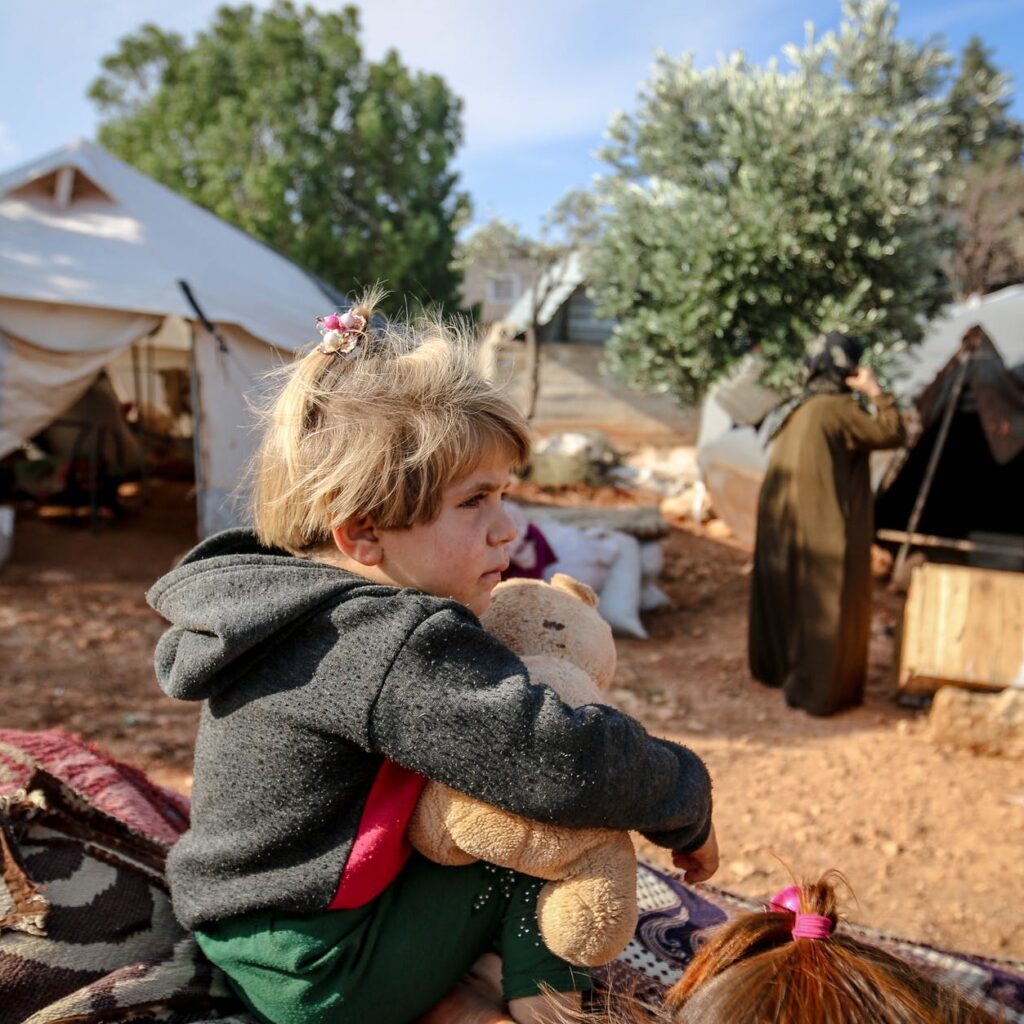 cute girl with toy in refugee camp