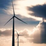 silhouette photo of two wind mills during golden hour