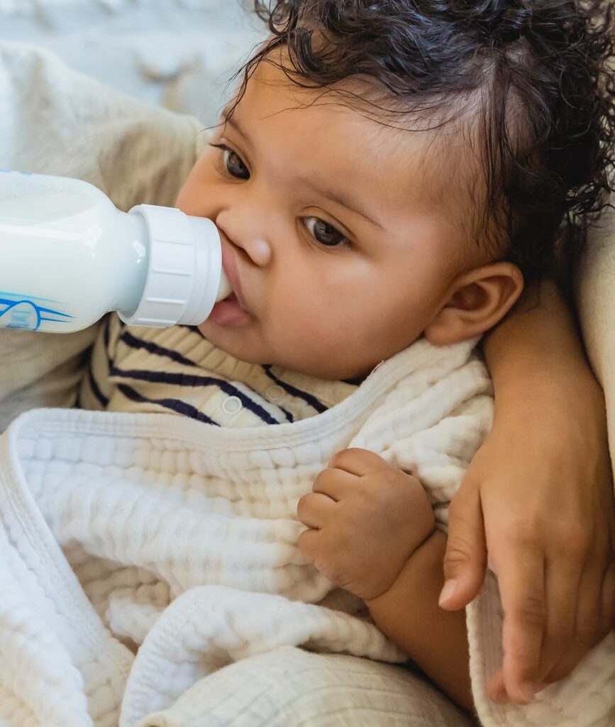 cute little baby drinking milk from bottle