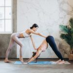 yoga instructor helping a student