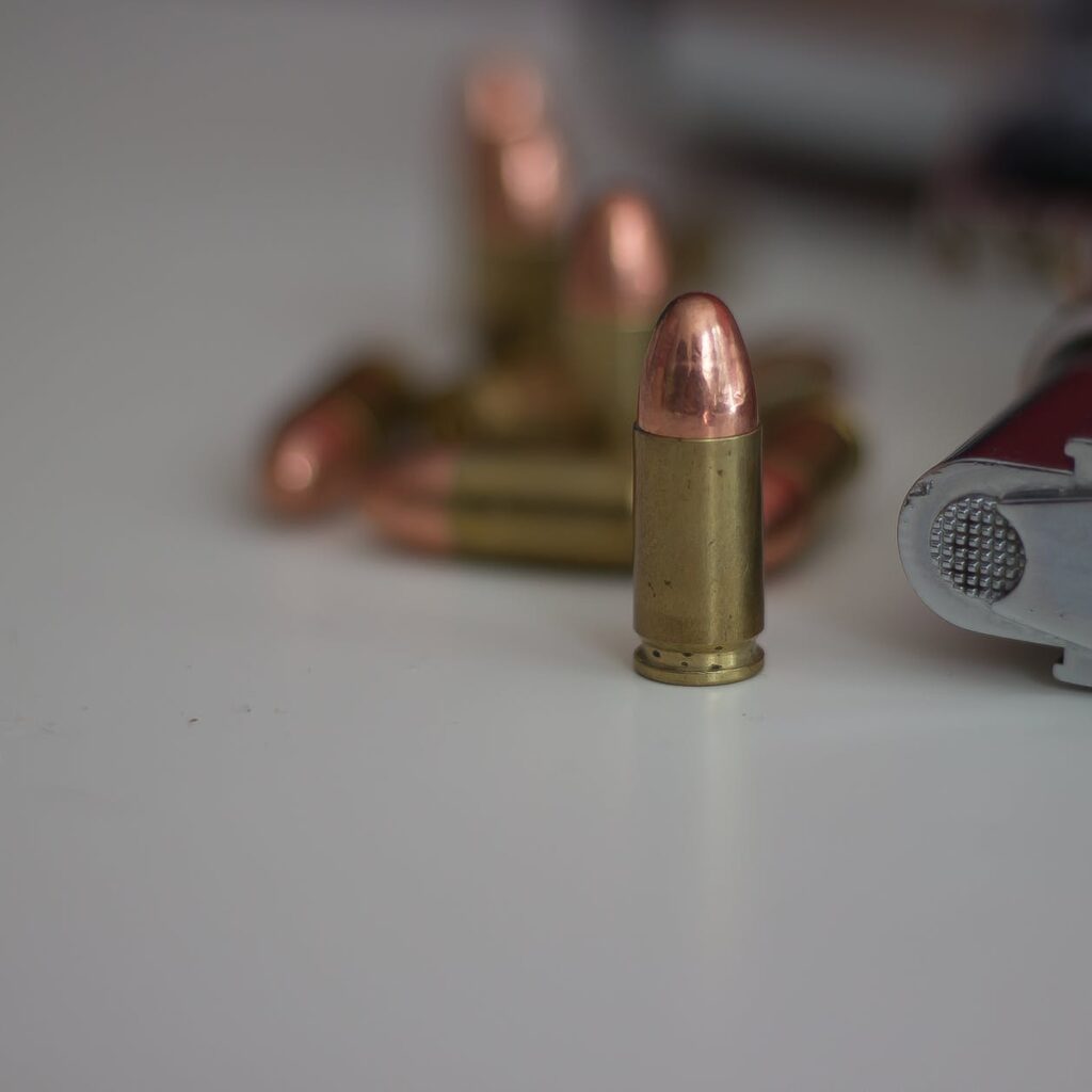close up of bullet beside a gun
