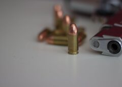 close up of bullet beside a gun