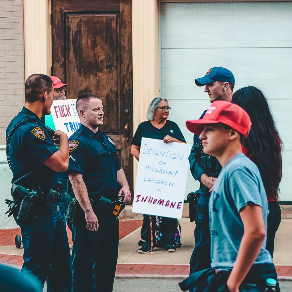 police standing near woman and man holding up signage