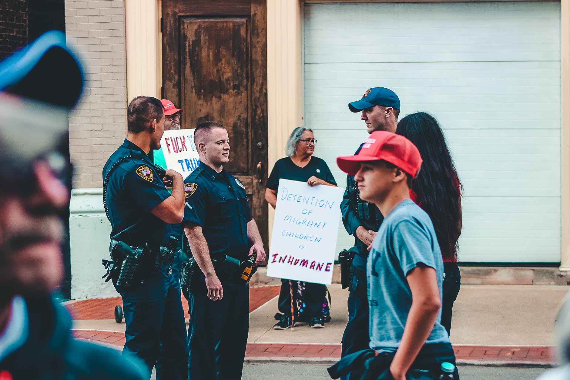 police standing near woman and man holding up signage