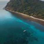 aerial photography of boat sailing near island