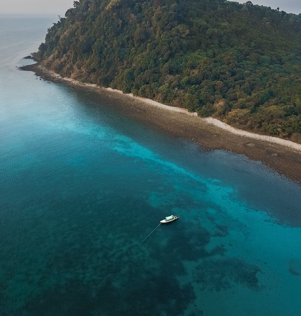 aerial photography of boat sailing near island