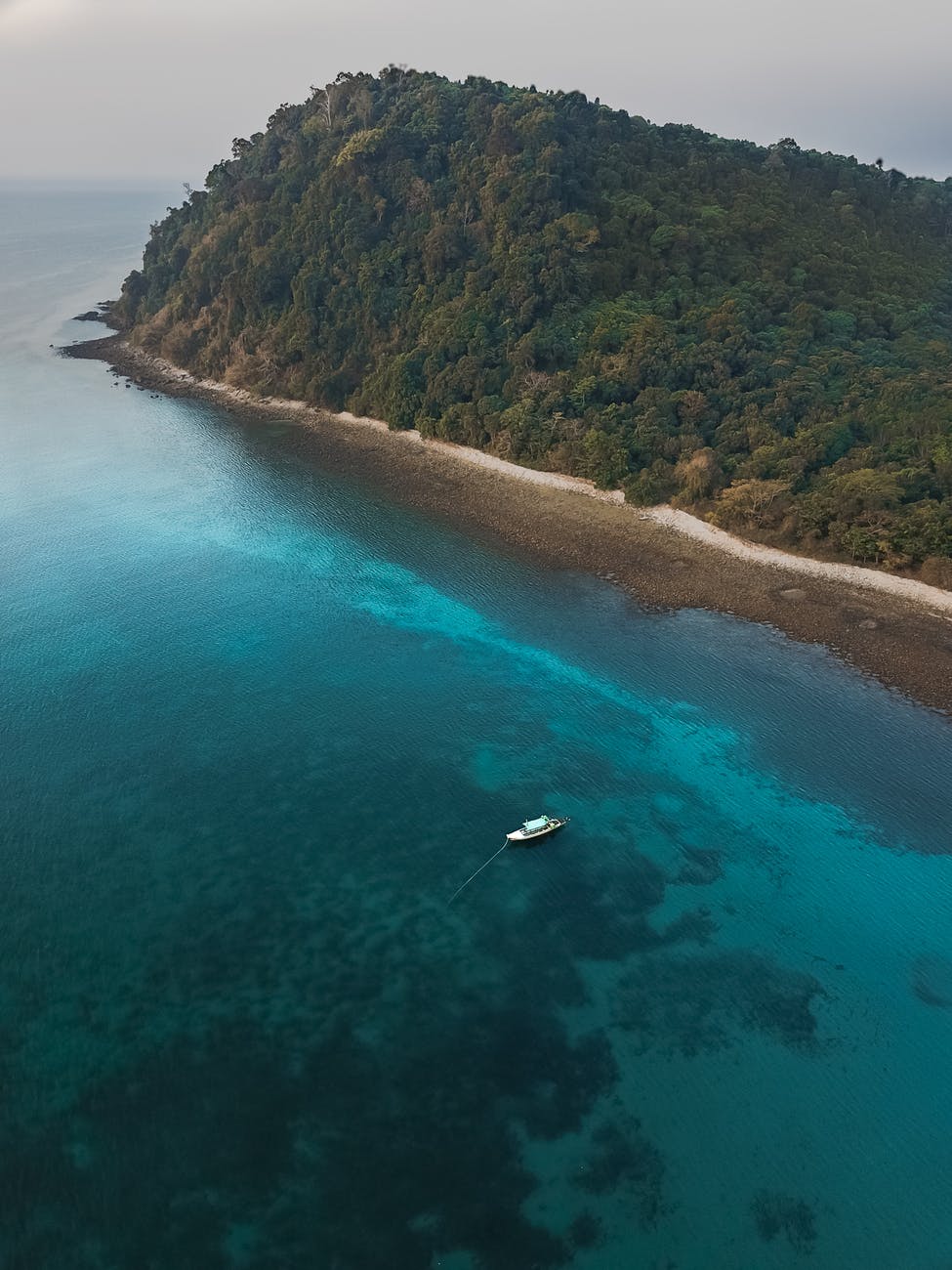 aerial photography of boat sailing near island