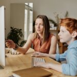 photo of woman tutoring young boy