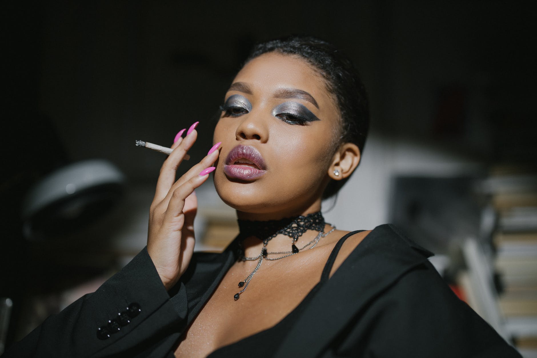 woman in black blazer holding cigarette stick