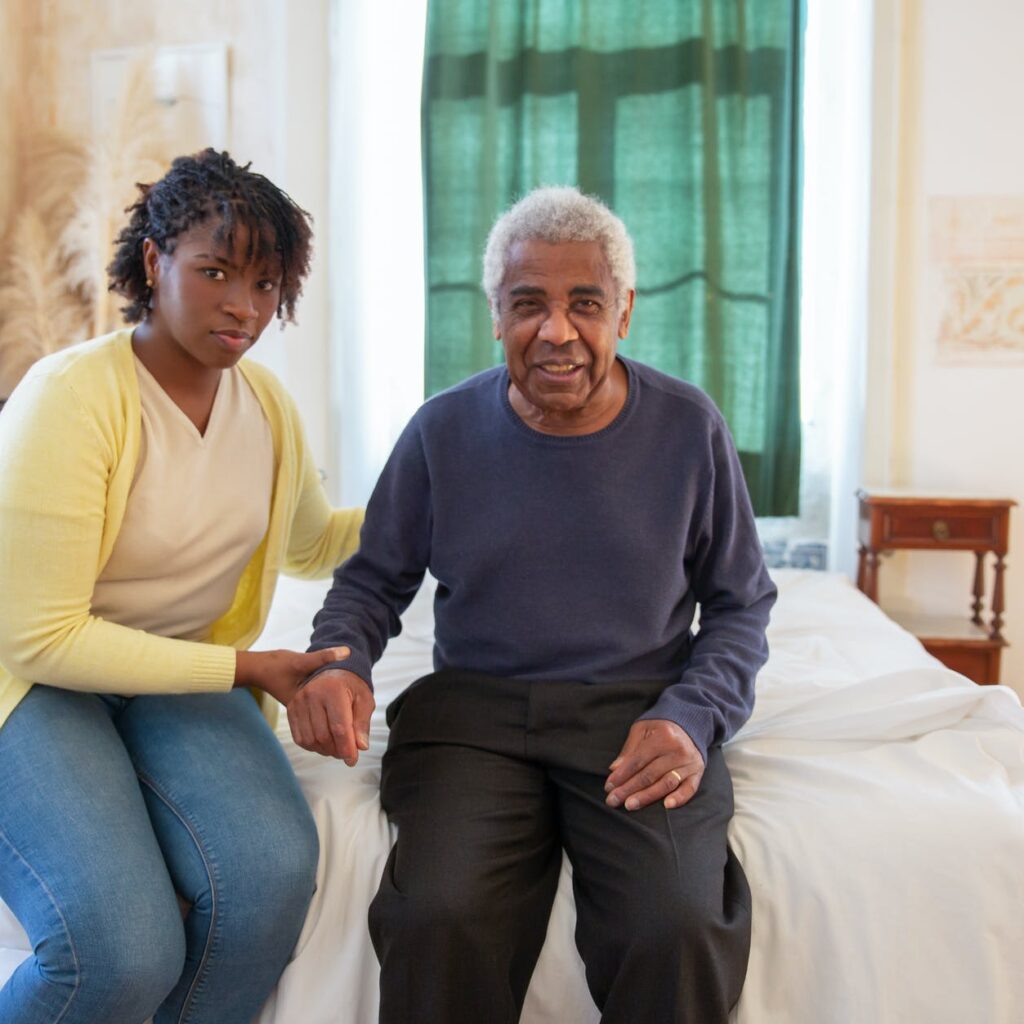woman and elderly man sitting on bed