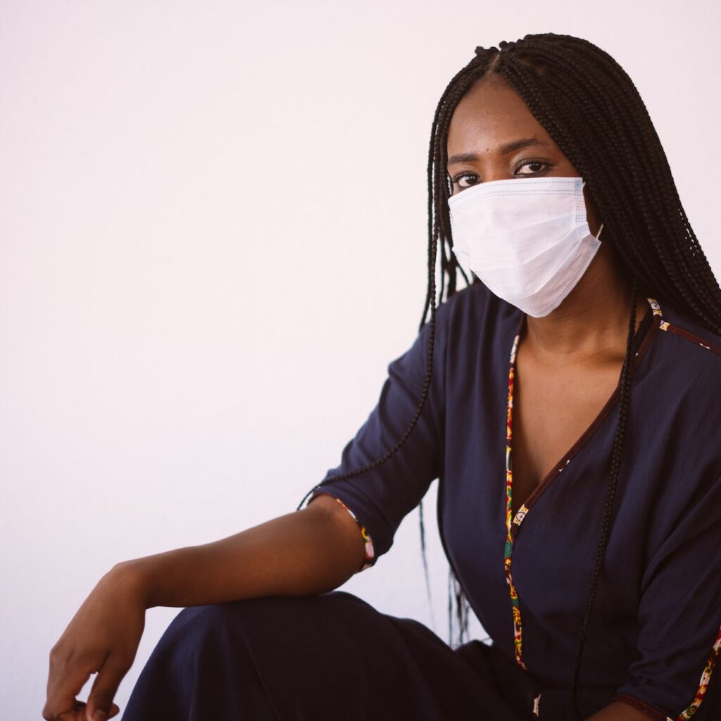 black woman in protective mask on gray background