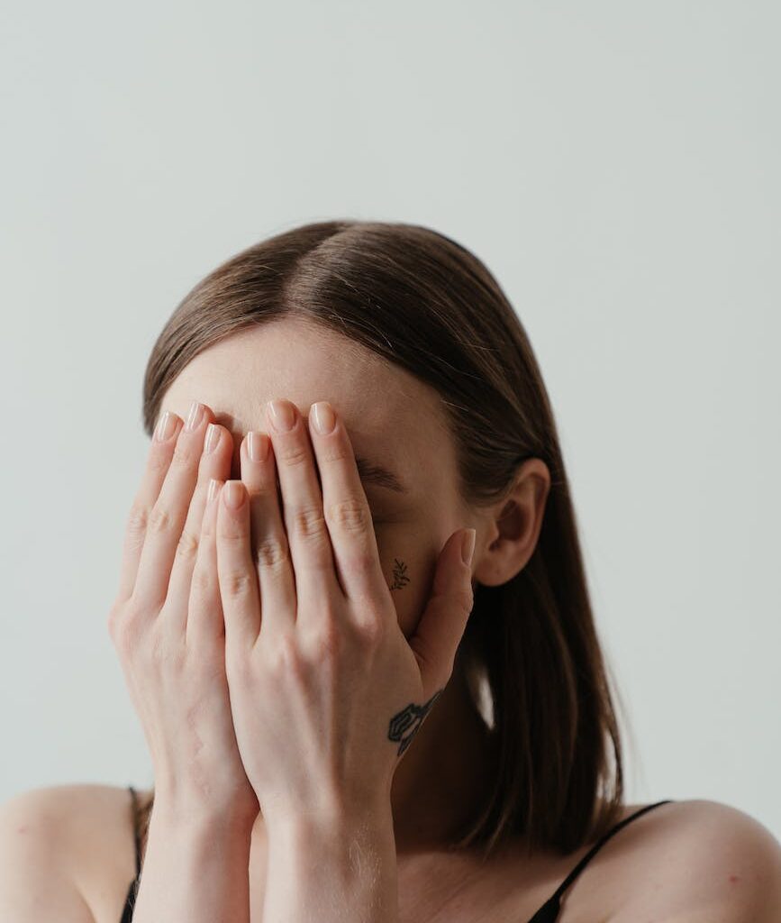 woman covering her face with her hands