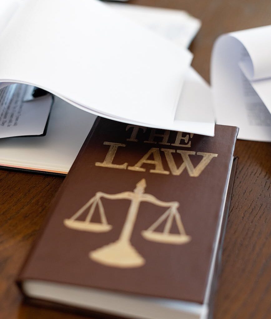 a law book on a wooden desk beside papers